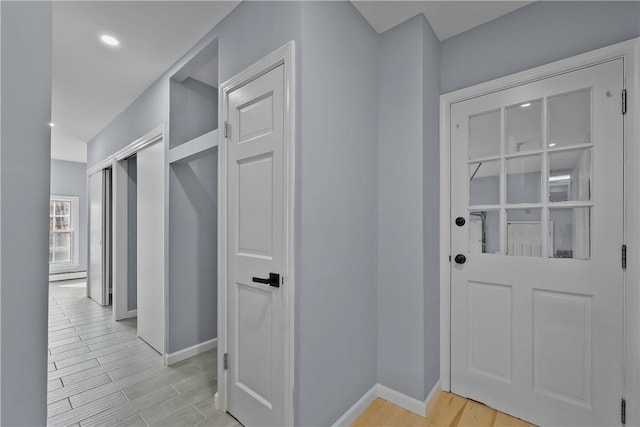 interior space featuring baseboards and light wood finished floors