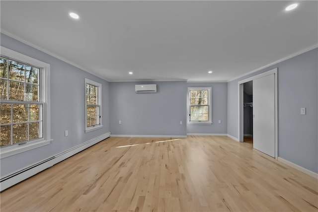 spare room featuring a baseboard heating unit, a wall mounted air conditioner, light wood-style flooring, and crown molding