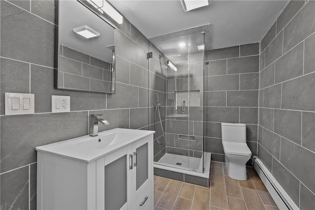 bathroom featuring tile walls, a baseboard radiator, toilet, a shower stall, and vanity