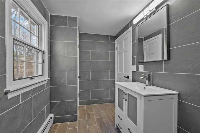 bathroom featuring wood finish floors, tile walls, and vanity