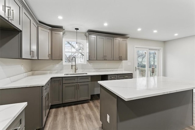 kitchen with wood finished floors, recessed lighting, a sink, and gray cabinetry