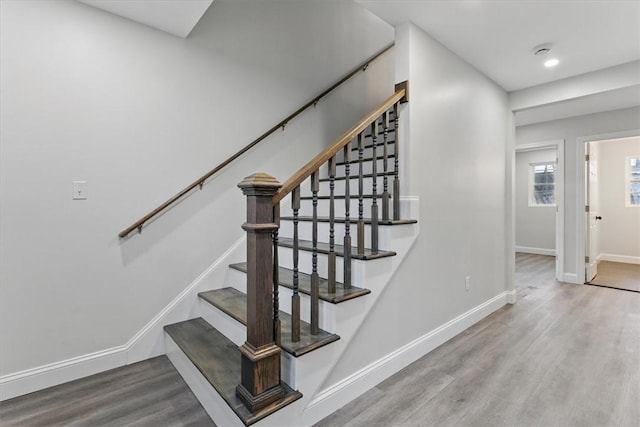 stairway featuring baseboards, wood finished floors, and recessed lighting