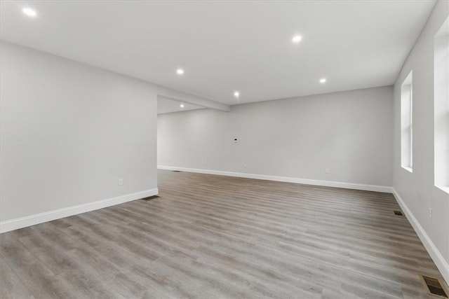 empty room featuring recessed lighting, baseboards, and wood finished floors