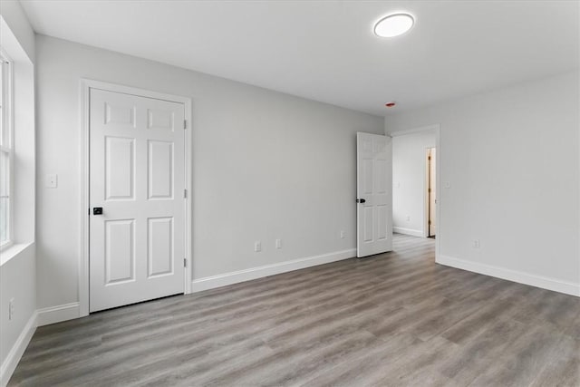 unfurnished bedroom featuring baseboards and wood finished floors