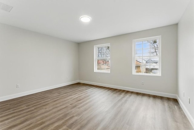 spare room with wood finished floors and baseboards