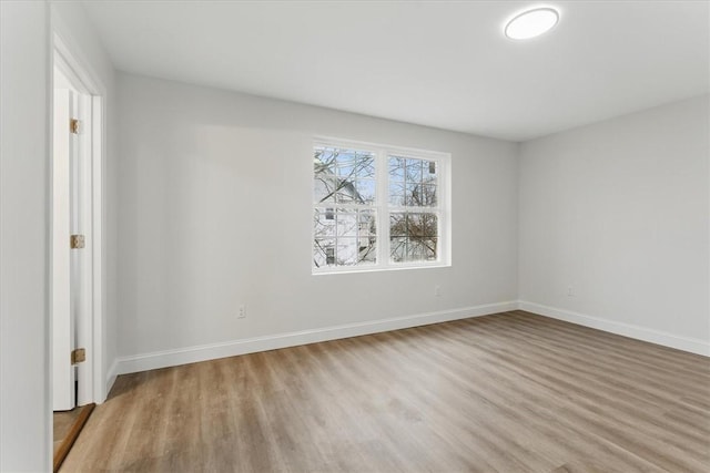 empty room featuring wood finished floors and baseboards