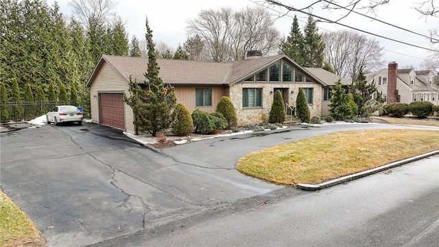 view of front of property with stone siding, a chimney, and fence