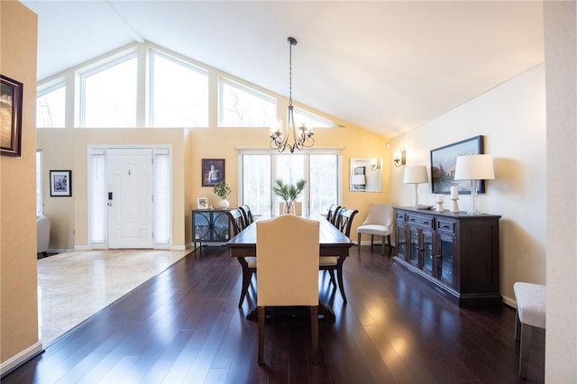 dining space featuring an inviting chandelier, baseboards, high vaulted ceiling, and wood finished floors