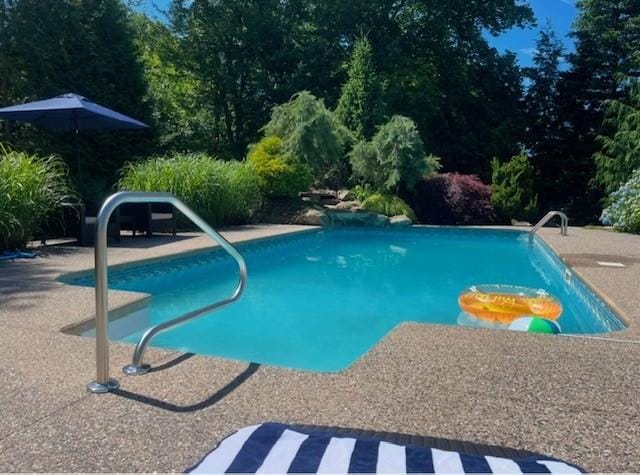 outdoor pool with a patio area