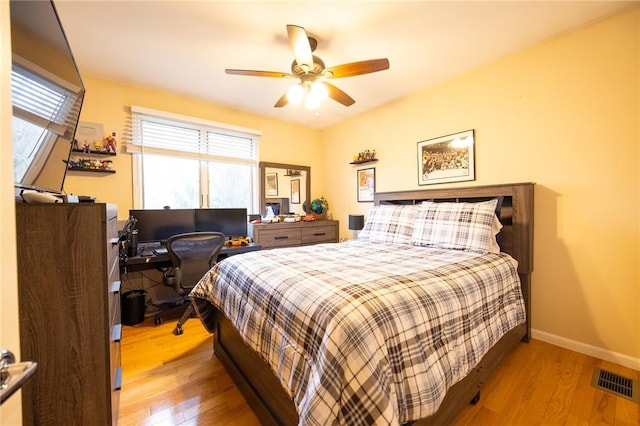 bedroom featuring visible vents, ceiling fan, baseboards, and wood finished floors