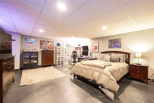 bedroom featuring concrete floors and a paneled ceiling