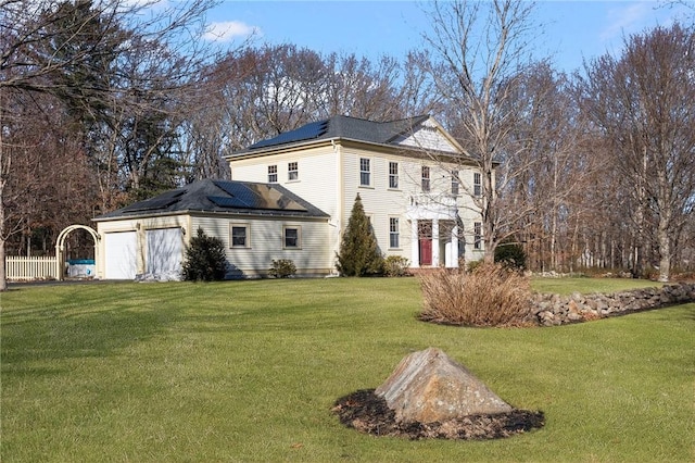 view of property exterior with a garage, a yard, fence, and solar panels