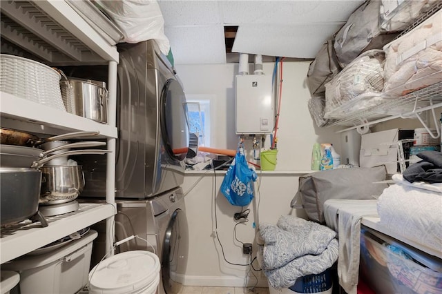 utility room with water heater and stacked washer and clothes dryer