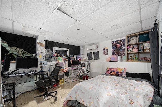 bedroom featuring a wall unit AC, a paneled ceiling, and tile patterned floors