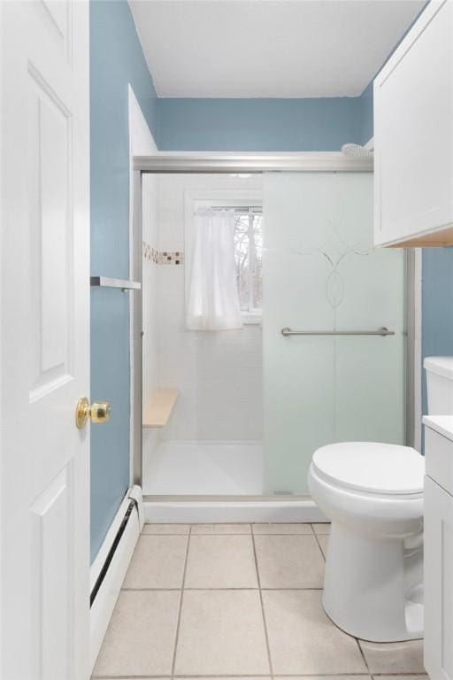 bathroom featuring toilet, tile patterned flooring, baseboard heating, vanity, and a shower stall