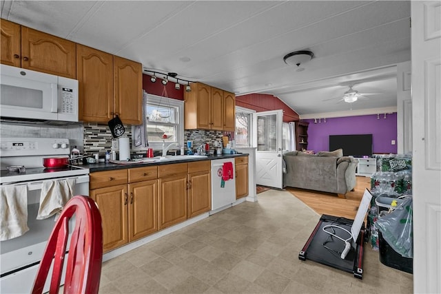 kitchen featuring brown cabinetry, white appliances, a sink, and light floors