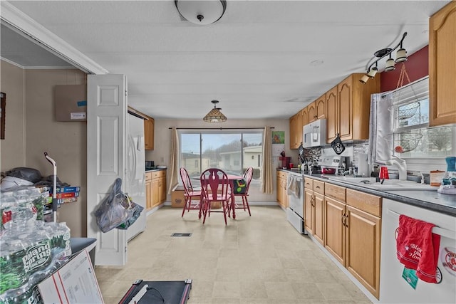 kitchen with white appliances, a sink, visible vents, light floors, and tasteful backsplash