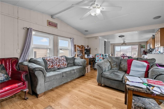 living room with lofted ceiling with beams, a ceiling fan, and light wood-style floors