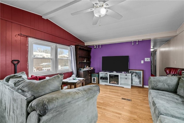 living area with lofted ceiling with beams, ceiling fan, visible vents, and light wood-style floors