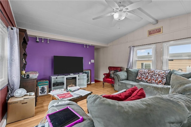 living area with ceiling fan, lofted ceiling with beams, baseboards, and wood finished floors