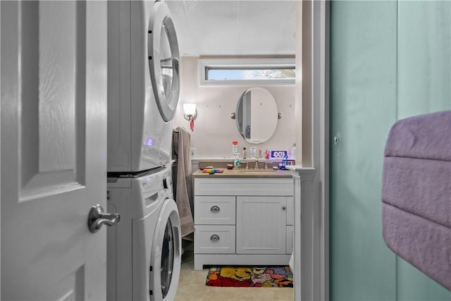 clothes washing area featuring laundry area, a sink, and stacked washer / drying machine