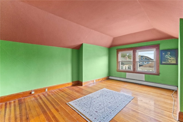 bonus room featuring a baseboard radiator, baseboards, vaulted ceiling, and wood finished floors