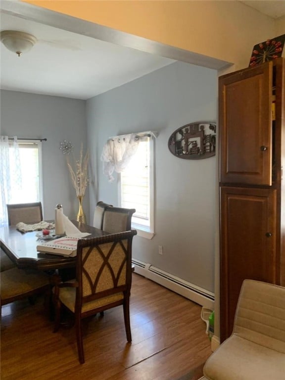 dining area with baseboard heating and wood finished floors