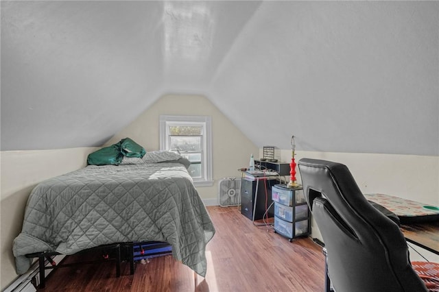 bedroom with lofted ceiling, wood finished floors, and baseboards