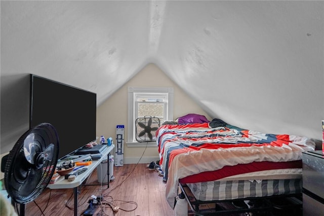 bedroom with wood-type flooring and vaulted ceiling