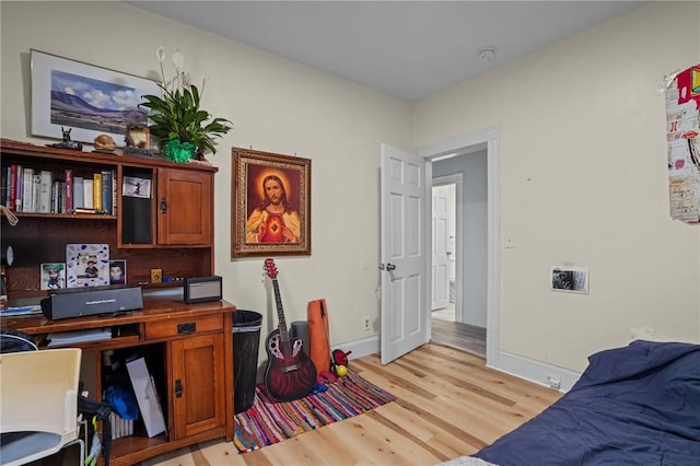 office space featuring baseboards and light wood-style floors