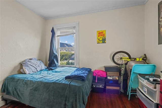 bedroom featuring wood finished floors and crown molding