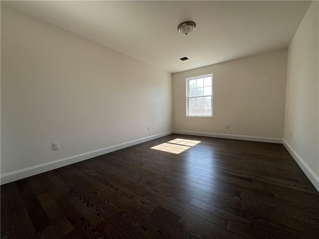 empty room with dark wood-style floors and baseboards