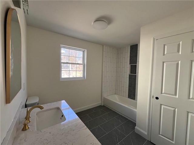 bathroom with shower / bath combination, a sink, toilet, and baseboards