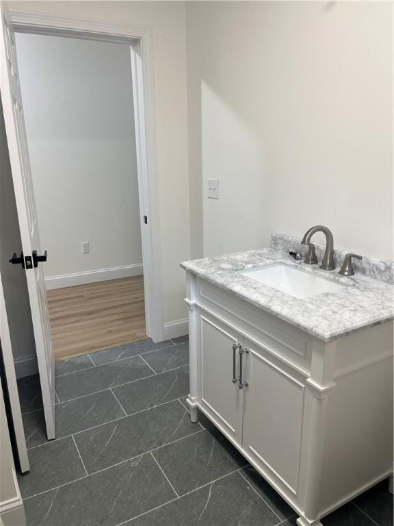 bathroom with tile patterned floors, baseboards, and vanity