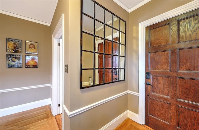 entrance foyer featuring light wood-type flooring, baseboards, and crown molding