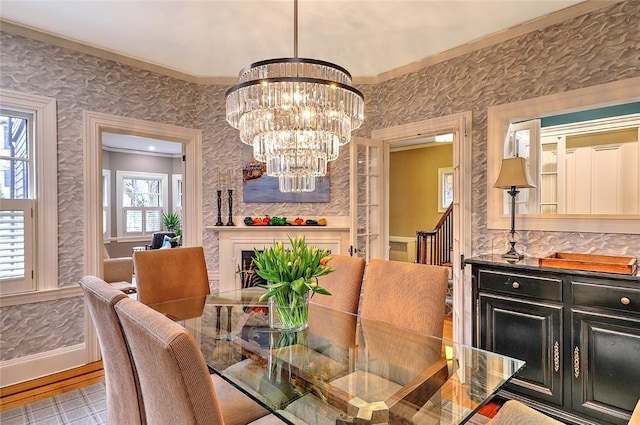 dining area featuring ornamental molding, baseboards, an inviting chandelier, and wallpapered walls