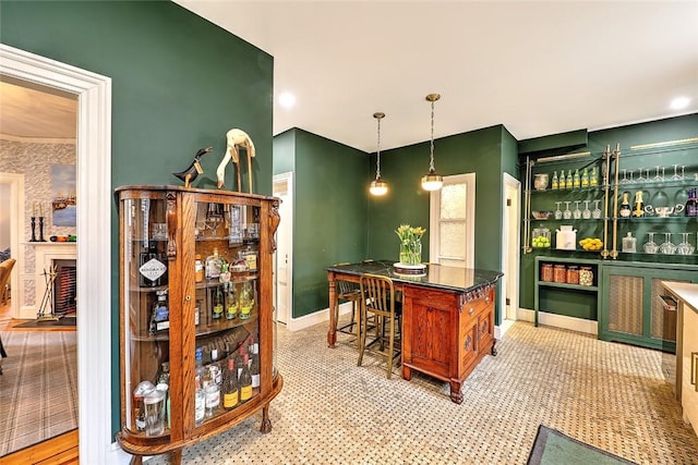 bar with hanging light fixtures, baseboards, and a dry bar