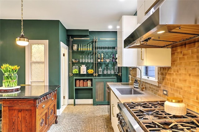 kitchen featuring extractor fan, a sink, white cabinets, gas range, and pendant lighting