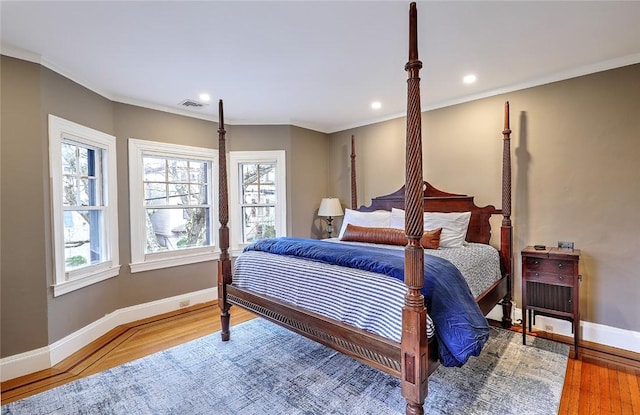 bedroom with recessed lighting, visible vents, ornamental molding, wood finished floors, and baseboards