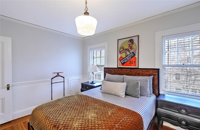 bedroom featuring a wainscoted wall and crown molding