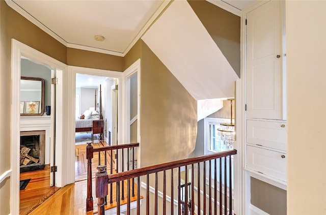 hall with light wood-type flooring, visible vents, and an upstairs landing