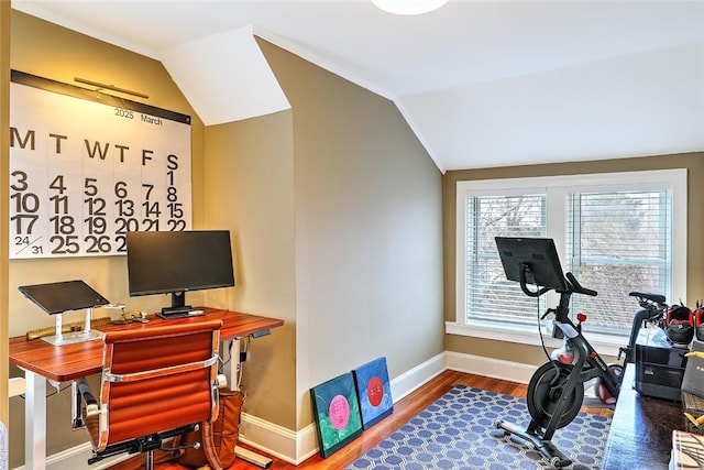 exercise area with vaulted ceiling, baseboards, and wood finished floors