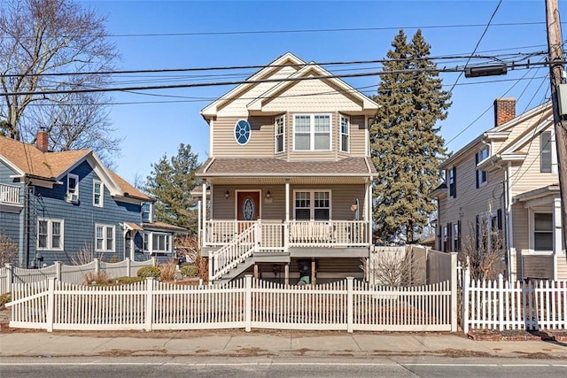 view of front of home featuring a fenced front yard, covered porch, and roof with shingles