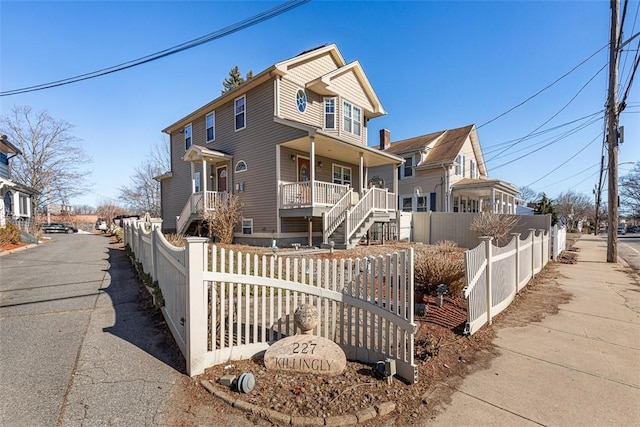 view of front of home with covered porch and a fenced front yard