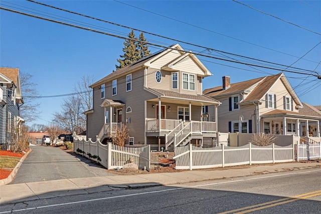 view of front of property with covered porch and a fenced front yard