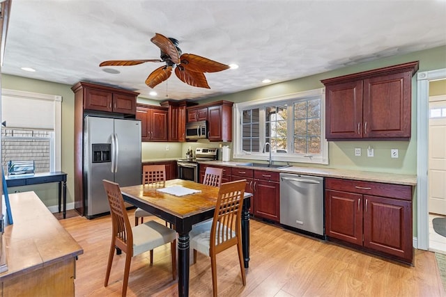 kitchen featuring recessed lighting, light countertops, appliances with stainless steel finishes, a sink, and light wood-type flooring