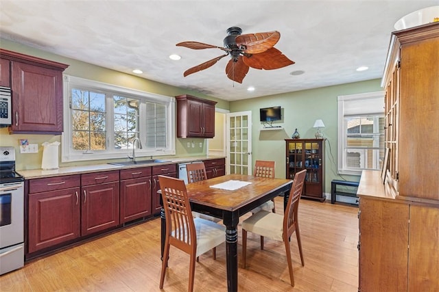 kitchen featuring recessed lighting, light countertops, light wood-style flooring, appliances with stainless steel finishes, and a sink