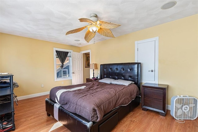 bedroom featuring ceiling fan, baseboards, and wood finished floors