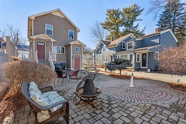 exterior space with entry steps, an outdoor fire pit, a patio area, and a residential view