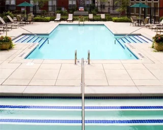 view of pool with a patio area and fence